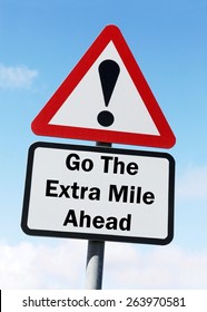 Red And White Triangular Road Sign With A Warning To Go The Extra Mile Ahead Concept Against A Partly Cloudy Sky Background