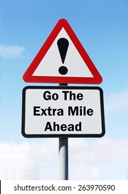 Red And White Triangular Road Sign With A Warning To Go The Extra Mile Ahead Concept Against A Partly Cloudy Sky Background