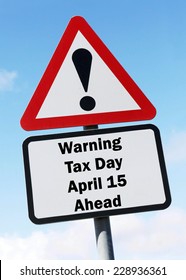 Red and white triangular warning road sign with a warning of tax day on April 15 ahead concept against a partly cloudy sky background