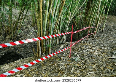 Red and white warning lines there is a barrier between the path leading to the waterfall. Demarcation line indicating prohibition of entry or prohibition of passing in dangerous areas.  - Shutterstock ID 2328236679