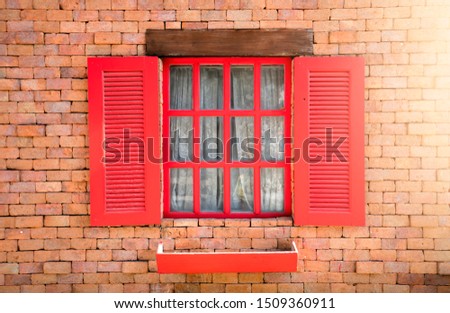 Red window with brick for background and sunrise.
