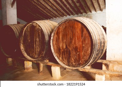 Red Wine Barrels Stacked In The Old Cellar Of The Vinery In Spain, Alicante. Toned Photo