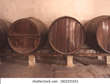 Red Wine Barrels Stacked In The Old Cellar Of The Vinery In Spain, Alicante. Toned Photo