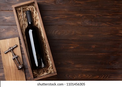 Red Wine Bottle In Box On Wooden Table. Top View With Space For Your Text