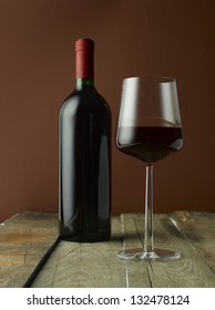 Red Wine Bottle and Elegance Glass on Wooden Table