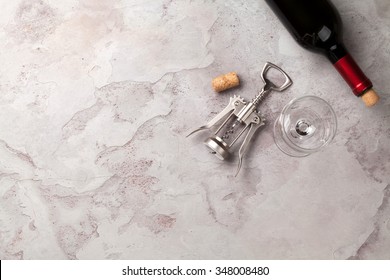 Red Wine Bottle, Glass And Corkscrew On Stone Table. Top View With Copy Space