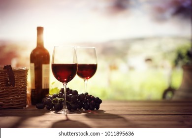 Red Wine Bottle And Glass On Table In Vineyard Tuscany Italy