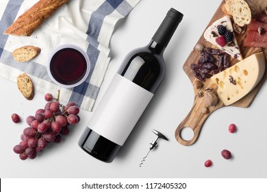 Red wine bottle mockup, on white background, with wine glass, food snacks and blank label to place your design