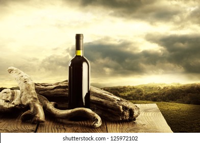 Red wine bottle and old wood, vineyard on background