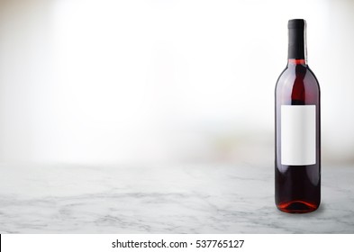 Red Wine In Bottle On White Marble Table.