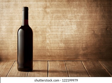 Red wine bottle on a wooden background - Shutterstock ID 122199979