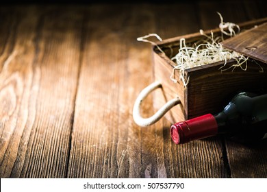 Red Wine Bottle And Wooden Crate In Wine Cellar