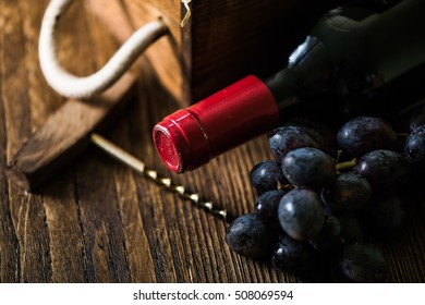 Red Wine Bottle And Wooden Crate In Wine Cellar