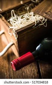 Red Wine Bottle And Wooden Crate In Wine Cellar