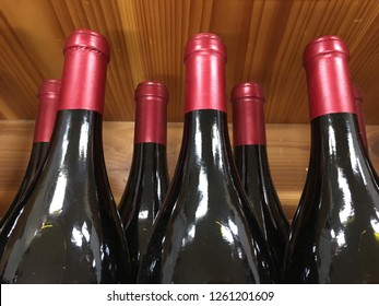 Red Wine Bottles With Red Cap Sit At A Shelf