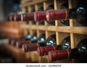 Red wine bottles stacked on wooden racks