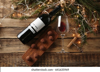 Red wine, chocolate dessert and Christmas decorations on wooden table