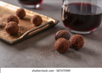 Red wine and chocolate truffles on table