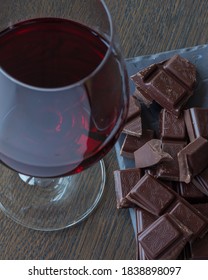Red wine and chocolates on a wooden table