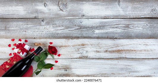 Red wine with envelope of hearts, gift box present and red rose on white rustic wood background for a happy Valentines day concept  - Powered by Shutterstock