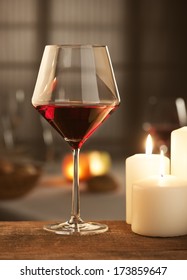 Red Wine Glass With Candlelight And Restaurant On Background.