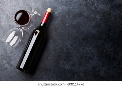 Red Wine Glasses And Bottle On Stone Background. Top View With Copy Space