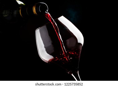 Red Wine From Grapes Of Pinot Noir Varieties Poured Into Large Wine Glass, Wine Tasting, On Dark Background, Low Key, Selective Focus