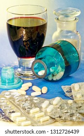 Red Wine, Half Empty Blister Packs Of Pharmaceutical Pills And Pills In Lying Glass Bottle And Outside It On Blue