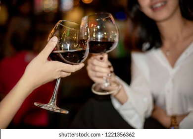 Red Wine Party. Romantic Lesbian Gay Couple Enjoying Dinner At Home, Love, Relationship, Romantic Concept. Happy Celebrating And Making Cheers With Glasses Of Red Wine Against Blurred Bokeh Night Club