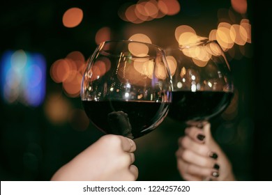 Red Wine Party. Romantic Lesbian Gay Couple Enjoying Dinner At Home, Love, Relationship, Romantic Concept. Happy Celebrating And Making Cheers With Glasses Of Red Wine Against Blurred Bokeh Night Club