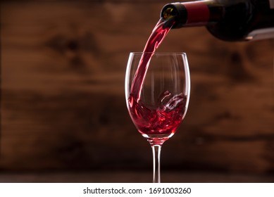 Red Wine Pouring Into Glass Old Wood Wall Background