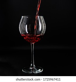 
Red Wine Pouring Into A Glass On A Black Background