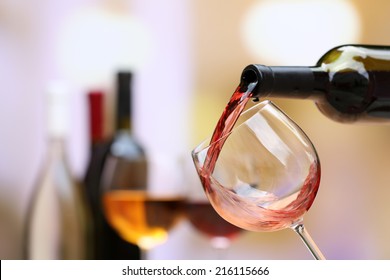 Red wine pouring into wine glass, close-up - Shutterstock ID 216115666