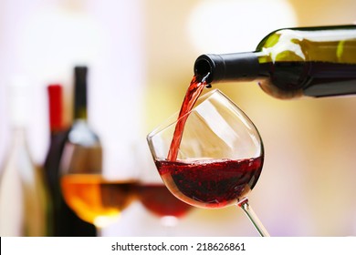 Red wine pouring into wine glass, close-up - Shutterstock ID 218626861