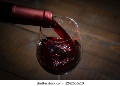 Red Wine Pouring Into A  Wineglass From A Bottel