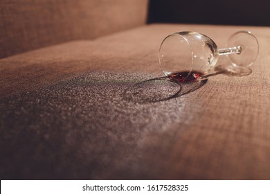 Red Wine Spilled On A Brown Couch Sofa.