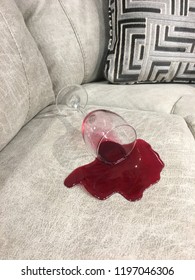Red wine spilled on a grey couch. 