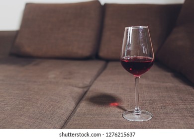 Red Wine Spilled On A Grey Couch Sofa.