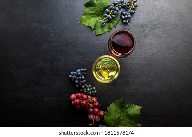 Red Wine And White Wine In Two Glasses Standing On Dark Rustic Background, Overhead View, Blank Space For A Text