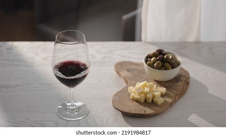 Red Wine In Wineglass With Antipasti On White Oak Table