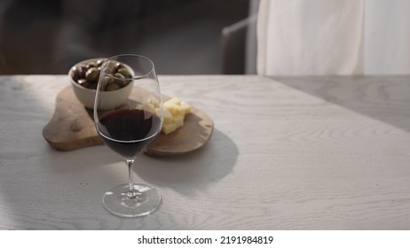 Red Wine In Wineglass With Antipasti On White Oak Table