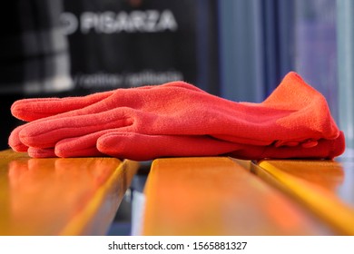 Red Women's Gloves Forgotten On A Bench Or At A Bus Stop On A Warm Sunny Day. Warehouse Or Lost And Found, Lost Things.