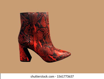 Red women's snakeskin Cowboy Boots isolated on brown background. Snake Cowboy Ankle Boots pattern. Close View Of Fashion Casual Female shoes. Brown snake Print Women Boots. Copy space - Powered by Shutterstock