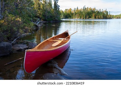 Red Wood Canoe On The Shore Of A Boundary Waters Lake In Morning Light During The Fall