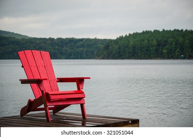 Red Wood Chair On Docks At Cottage Lake