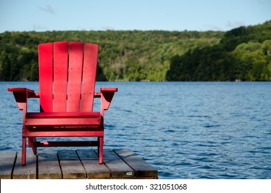 Red Wood Chair On Docks At Cottage Lake