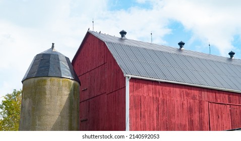 Red Wooden Barn With Concrete Silo On Small Hobby Farm In Ontario Barn With New Silver Metal Roof Freshly Painted Red Wood Slats Horizontal Format Room For Type Content Or Logo Blue Sky In Background 