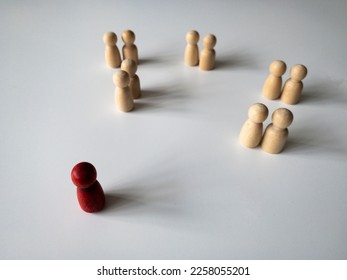 Red wooden being ignored by other doll figure on white background. Harassment and bully concept - Shutterstock ID 2258055201