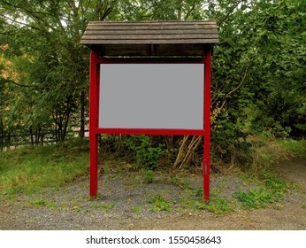 Red Wooden Billboard In A Park, Mock Up. Graphic Resource. Nobody.