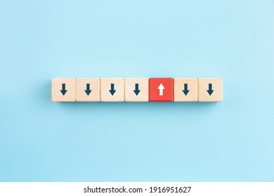 Red Wooden Block With Arrow Facing Individual Pointing In The Different Way On Blue Background, Business Icon For Innovative Solution,Unique, Think Different And Individual Concept.